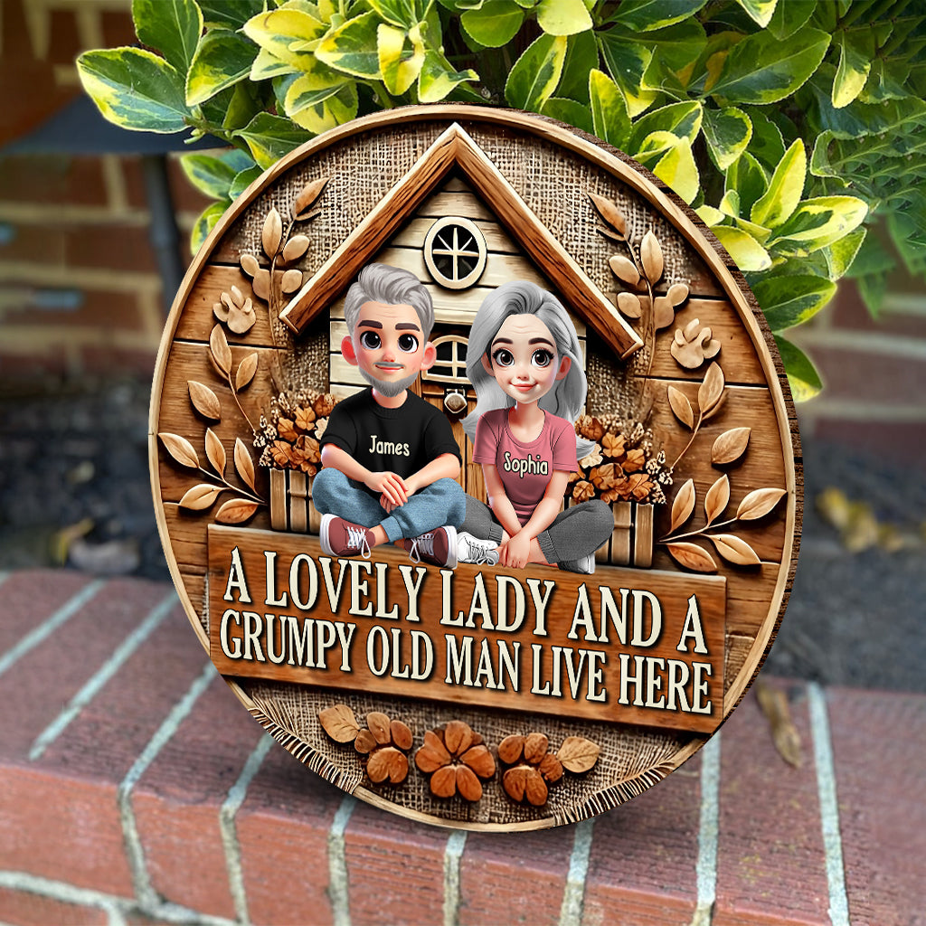 Hier wohnen eine reizende Dame und ein mürrischer alter Mann – personalisiertes rundes Holzschild für Paare