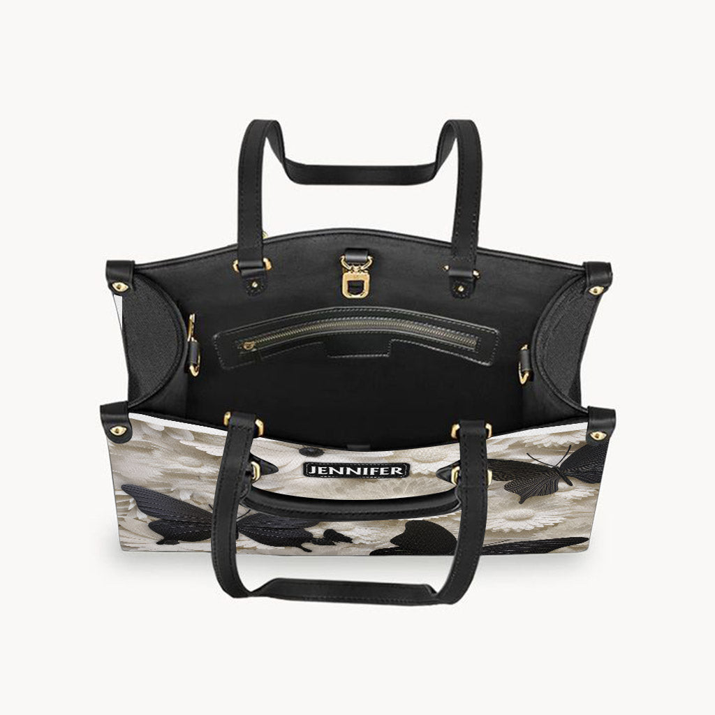Elegante, personalisierte Schmetterlings-Lederhandtasche in Schwarz und Weiß mit Schmetterlingen und Blumen