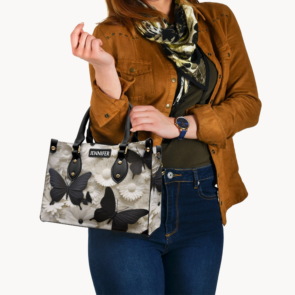 Elegante, personalisierte Schmetterlings-Lederhandtasche in Schwarz und Weiß mit Schmetterlingen und Blumen